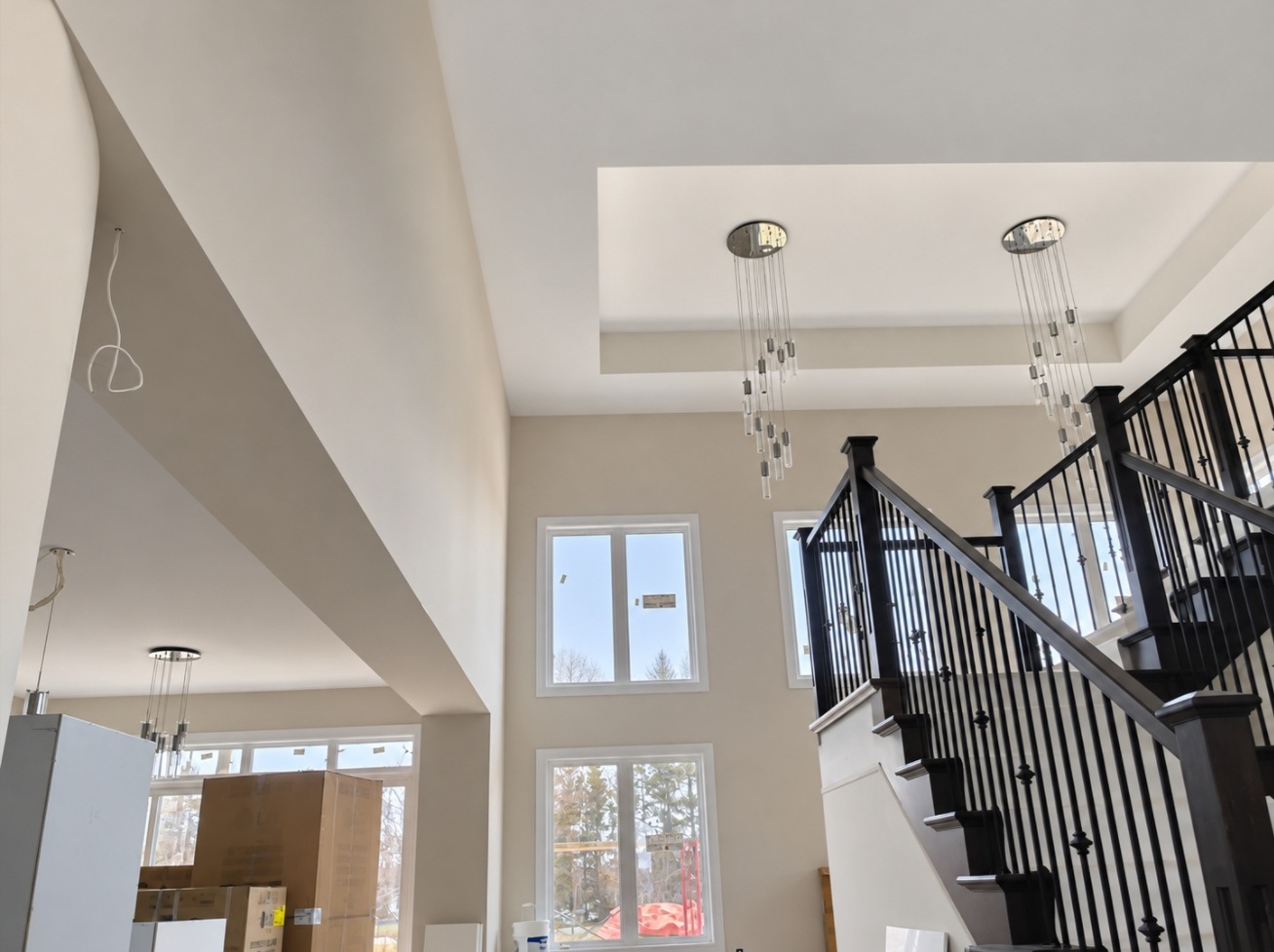 Finished stairwell — smooth surfaces around a recessed ceiling and tall openings.